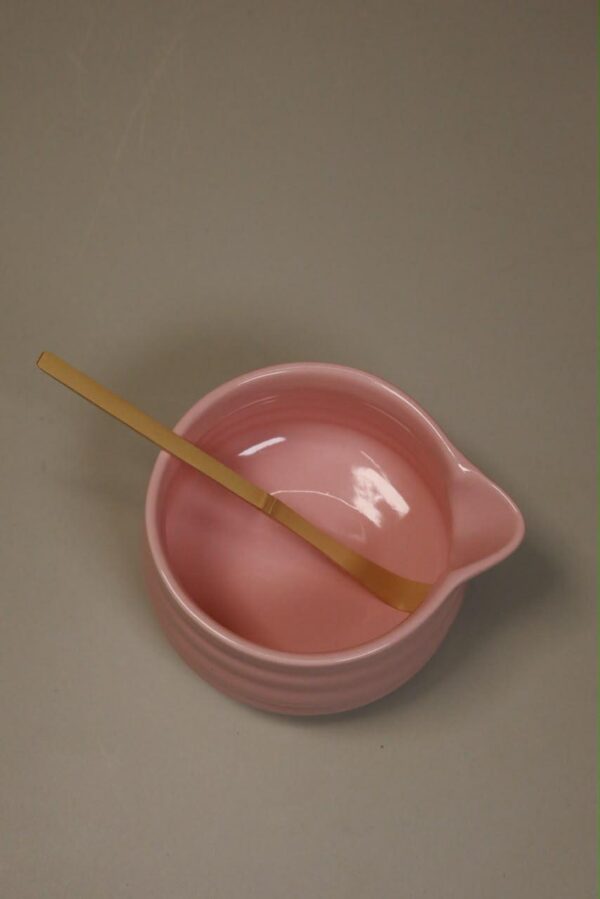 Pink chawan bowl with a bamboo chashaku scoop